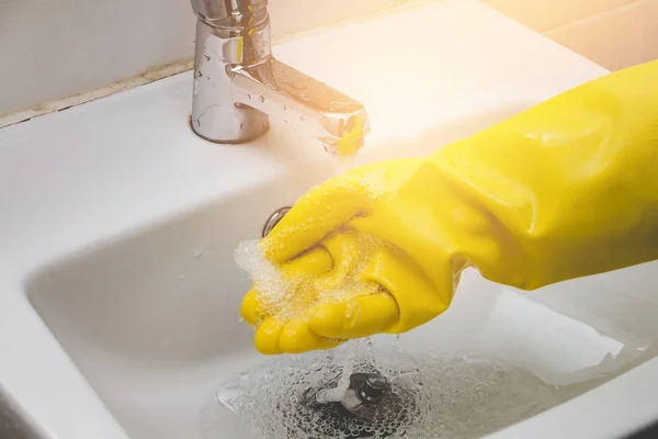 Hand of water tap housemaid wearing yellow glove cleaning — Stock Photo, Image