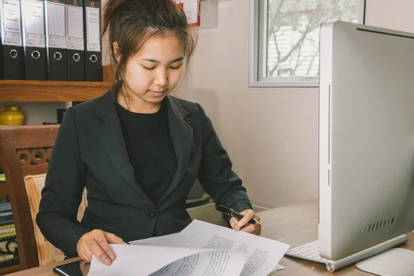 Businesswoman checking terms and conditions at her desk
