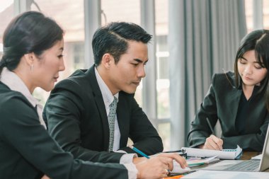 Dizüstü bilgisayar ile iki Sekreter alarak notları kullanarak iş adamı