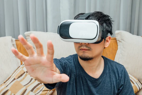 Aziatisch mens VR-bril uiten op brown dus Stockafbeelding