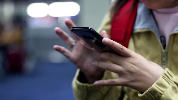 Backpacker utilisant et tapant smartphone pour vérifier quelque chose à l'aéroport  