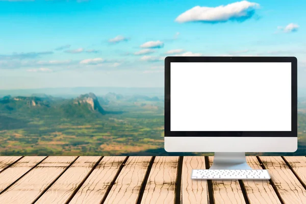 Modern computer blank monitor screen on wooden table with view p