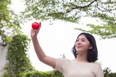 Mini kırmızı kalp gösterilen ve gülümseyen, aşk kavramı kız el, 
