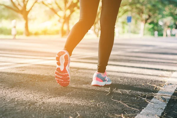 Jovencita corriendo por la carretera de cerca en zapato., al atardecer — Foto de Stock