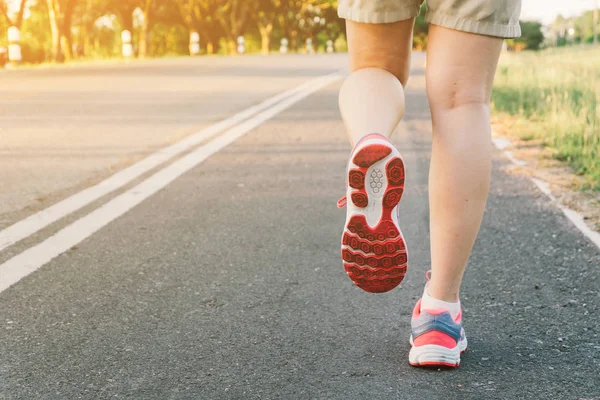 Yol portre üzerinde ayakkabı., üzerinde zaman günbatımı çalışan genç bayan