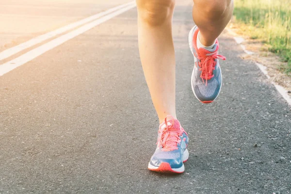 Jovencita corriendo por la carretera de cerca en zapato., al atardecer — Foto de Stock