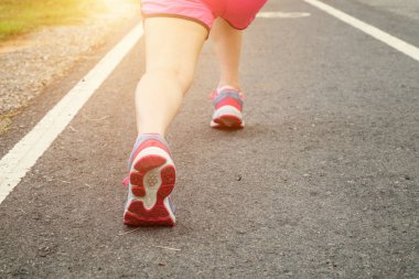 Ayakkabı genç bayan yolda çalışan closeup., saat gün batımında