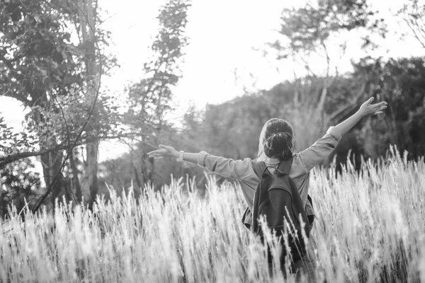 Hipster genç kız ormanda sırt çantası yürüyüş ile atlamak., zaman dinlenmek ve etrafında doğanın tadını çıkarın., Siyah ve beyaz sesi