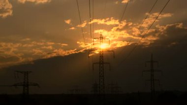 Yüksek voltajlı elektrik hatları gün batımında