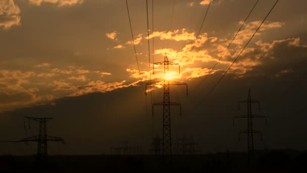 Yüksek voltajlı elektrik hatları gün batımında — Stok video