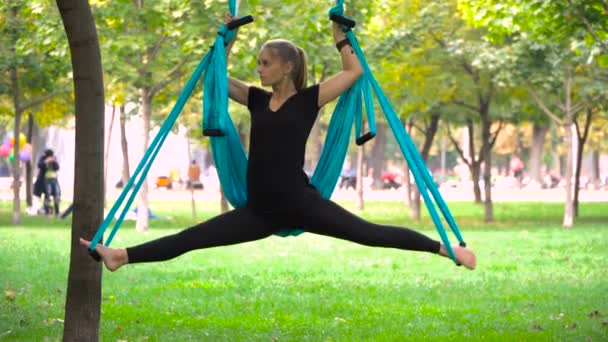 Girl in a park engaged in aerial yoga — Stock Video