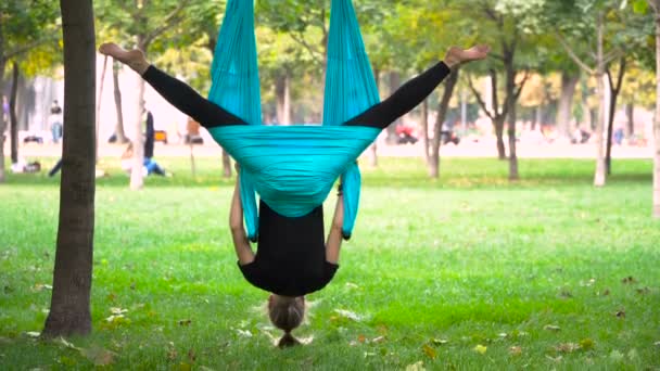 Fille dans un parc engagé dans le yoga aérien — Video