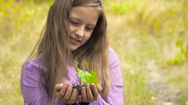 Das Mädchen mit einer Pflanze in der Hand — Stockvideo