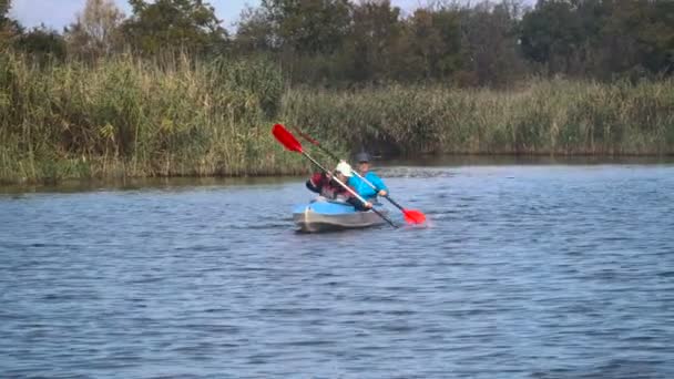 Les filles dans un canot sur la rivière 