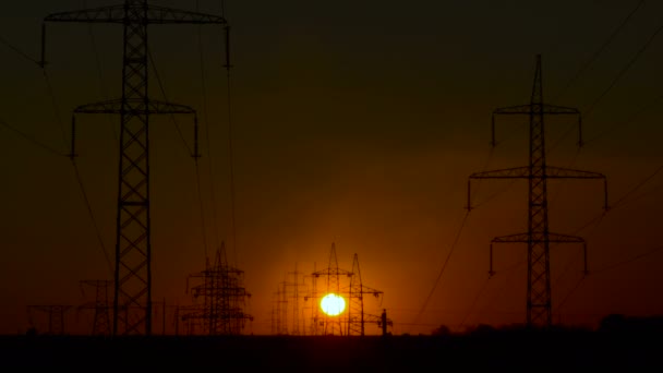 Línea de alimentación de alto voltaje y la puesta del sol . — Vídeos de Stock