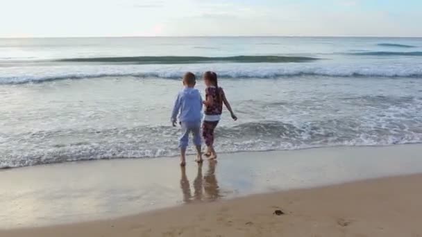 Dzieci bawiące się na brzegu morza. — Wideo stockowe