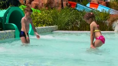 Çocuklar havuzda oynuyor.