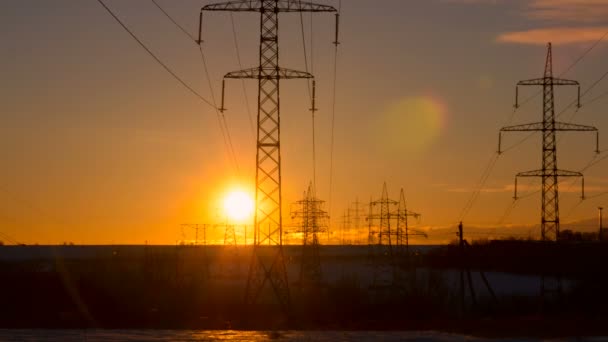 Pôr do sol em um fundo de uma linha de alta tensão — Vídeo de Stock