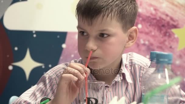 Мальчик пьет сок с помощью трубки — стоковое видео