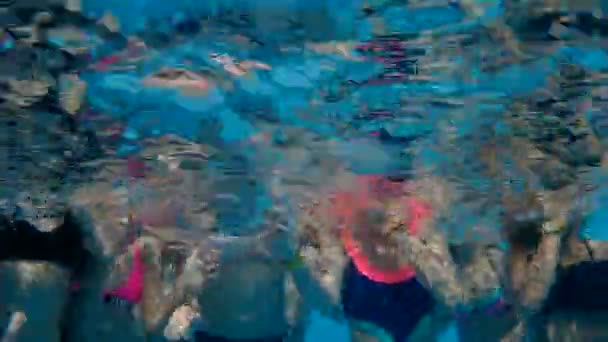Los niños nadan en la piscina bajo el agua — Vídeos de Stock