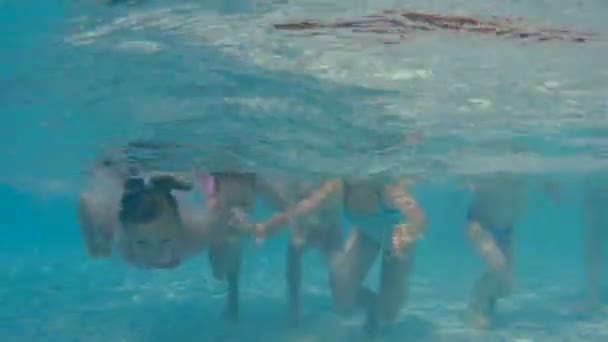 Los niños nadan en la piscina bajo el agua — Vídeos de Stock