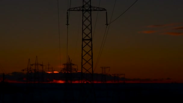 Високовольтні лінії електропередач на сході сонця . — стокове відео
