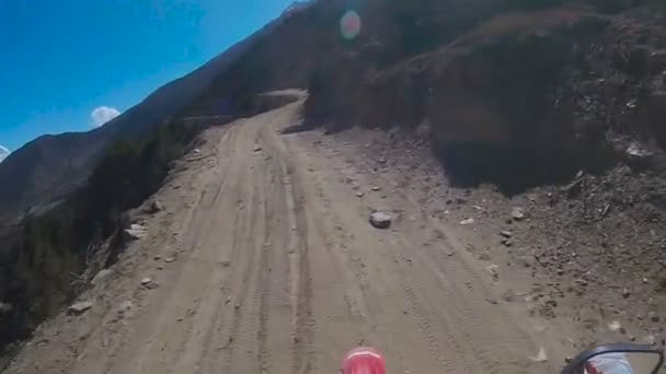 Un motociclista monta en una peligrosa carretera de montaña — Vídeos de Stock