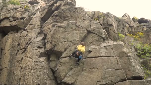 Genç adam kaya tırmanışı — Stok video