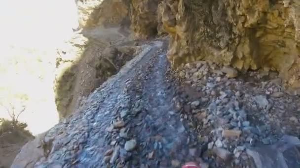 Мотоциклист едет по опасной горной дороге — стоковое видео