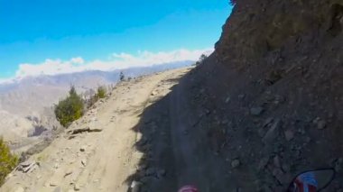 Bir tehlikeli dağ yolda bir motosikletçi rides