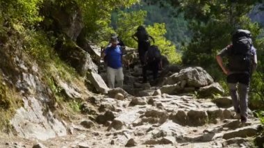 Birçok turist ve yataklı vagon görevlilerine çıkmak ve kayalık Lukla-Namche yol Manjo Köyü yakınındaki inerler