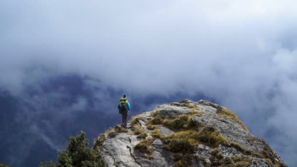 Girl with backpack reaching up top of mountain and raised hands — Stock Video