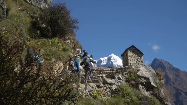 许多游人和搬运工登高和下降在岩石卢克拉-Namche 路附近 Manjo 村庄 — 图库视频影像