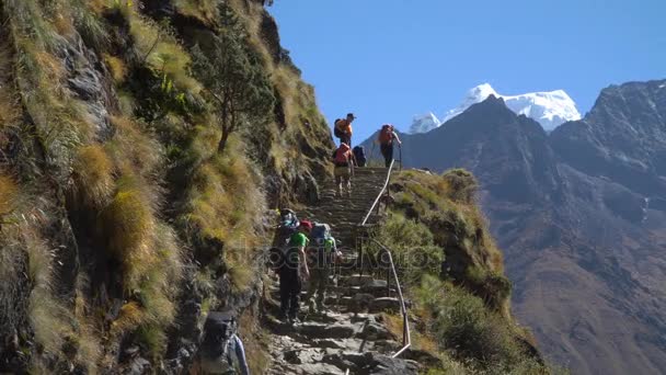 Birçok turist ve yataklı vagon görevlilerine çıkmak ve kayalık Lukla-Namche yol Manjo Köyü yakınındaki inerler — Stok video