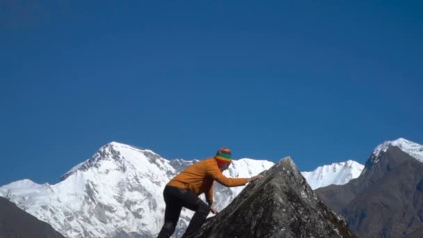 Hombre alcanzando la cima de la montaña y las manos levantadas — Vídeos de Stock