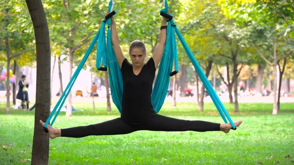 Menina em um parque envolvido em ioga aérea Fotos De Bancos De Imagens