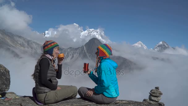 Две девушки пьют чай в горах. — стоковое видео