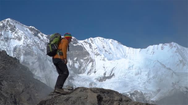 Турист взбирается на скалу в Гималаях — стоковое видео