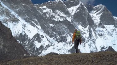 Bir adam bir sırt çantası ile dağlarda seyahat