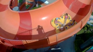 Mutlu kız su parkında kaydırağı aşağı gidiyor