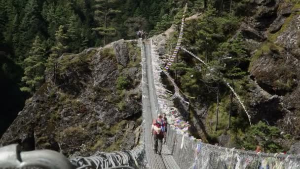 Grupo de excursionistas cruzan puente colgante . — Vídeo de stock