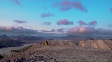Sırt çantalı bir adam Landmannalaugar doğa manzarasında seyahat eder.