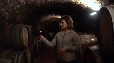 Bir kadın bir kadeh şarap elinde tutar.