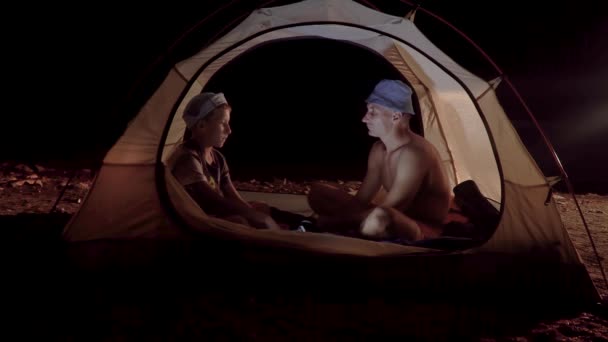 Son and father in a tent at night — ストック動画