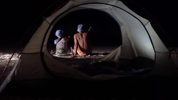 밤에 텐트 근처에 있는 아들 과 아버지 — 비디오