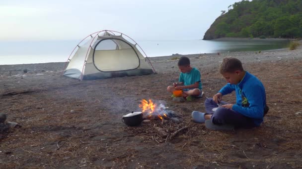 Los niños comen cerca del fuego — Vídeo de stock