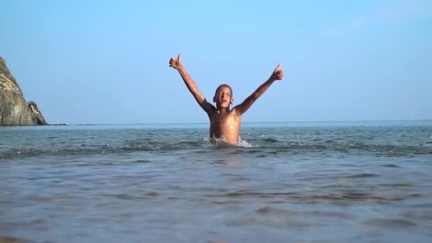 Het kind baadt en speelt in de zee — Stockvideo