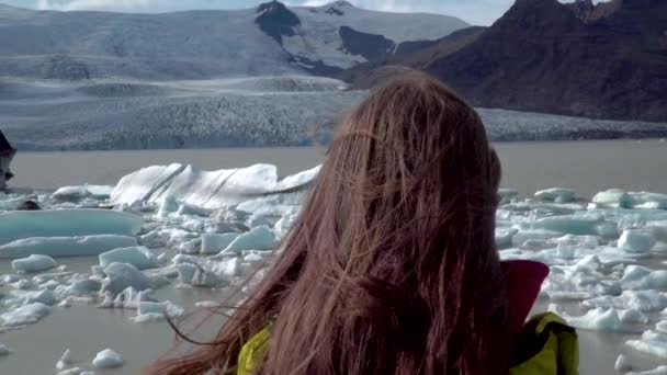 Mädchen mit langen Haaren blickt auf Fjallsarlon-Gletscherlagune — Stockvideo