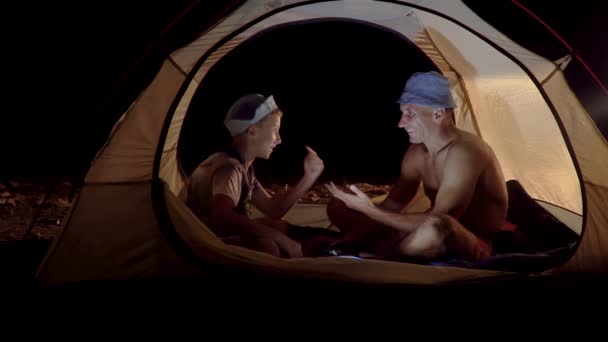 Сын и отец в палатке ночью — стоковое видео