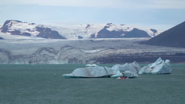 Un barco flotando entre icebergs — Vídeos de Stock